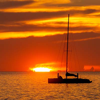 Watch the sun sink below the horizon on a barefoot sail. You may even see the “green flash”!