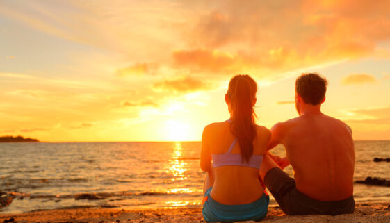 Happy,Romantic,Couple,Enjoying,Beautiful,Sunset,At,The,Beach,Sitting